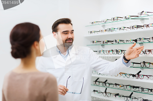 Image of woman and optician showing glasses at optics store