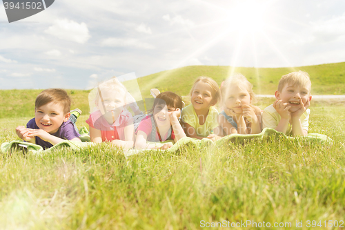 Image of group of kids lying on blanket or cover outdoors