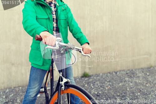 Image of close up of man with fixed gear bike on street