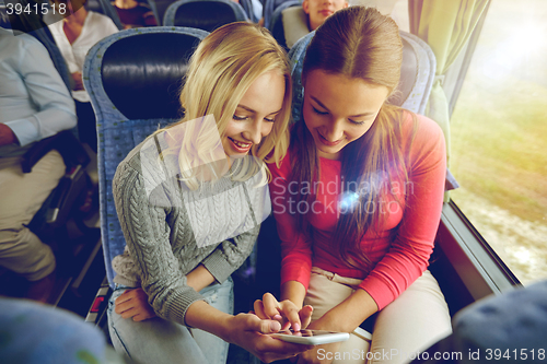 Image of happy young women in travel bus with smartphone