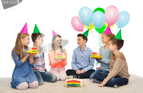 Image of happy children in party hats with birthday cake