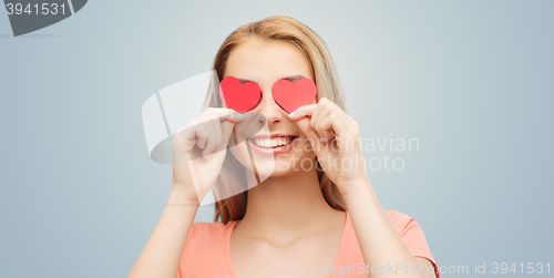 Image of happy young woman with red heart shapes on eyes