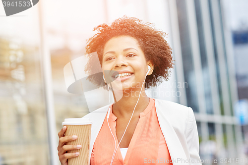 Image of happy african businesswoman with coffee in city