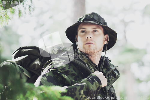 Image of young soldier with backpack in forest