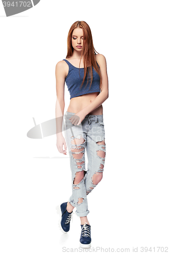 Image of Modern red haired female wearing distressed jeans