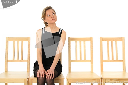 Image of Young lady sitting on a chair and waiting