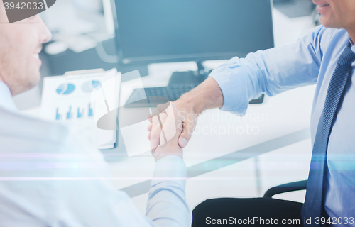 Image of businessmen shaking hands in office