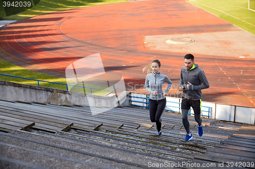 Image of happy couple running upstairs on stadium