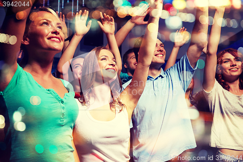 Image of smiling friends at concert in club