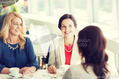 Image of women drinking coffee and talking at restaurant