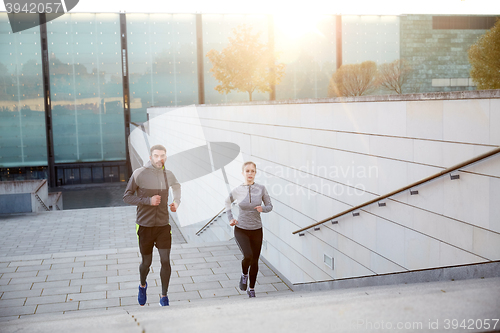 Image of happy couple running upstairs on city stairs