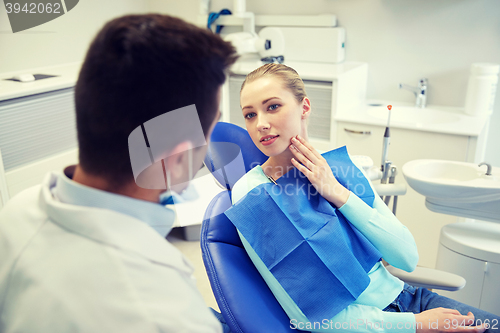 Image of male dentist with woman patient at clinic