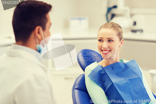 Image of happy male dentist with woman patient at clinic