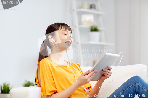 Image of happy asian woman with tablet pc and earphones