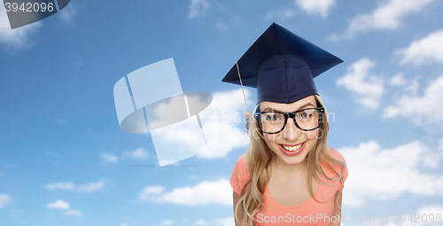 Image of smiling young student woman in mortarboard