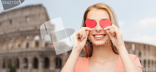 Image of happy young woman with red heart shapes on eyes