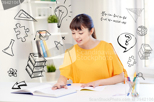 Image of happy asian young woman student learning at home