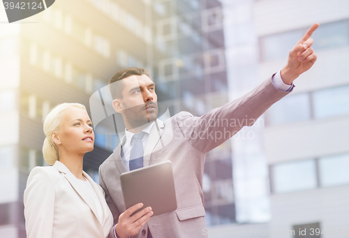 Image of businesspeople with tablet pc over office building