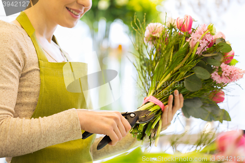 Image of close up of florist woman with flowers and pruner