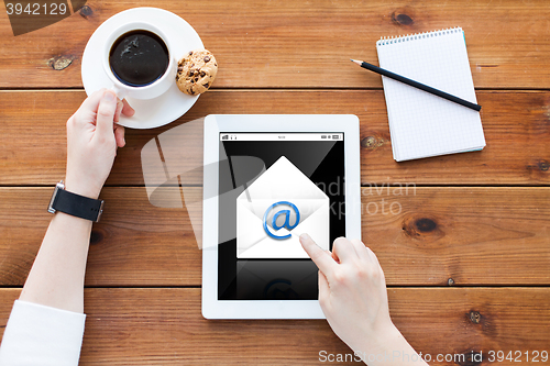 Image of close up of woman with tablet pc on wooden table