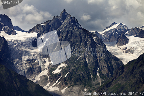 Image of Mountains with glacier in clouds before rain