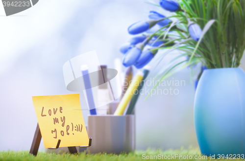 Image of Adhesive note with Love my job text at green office