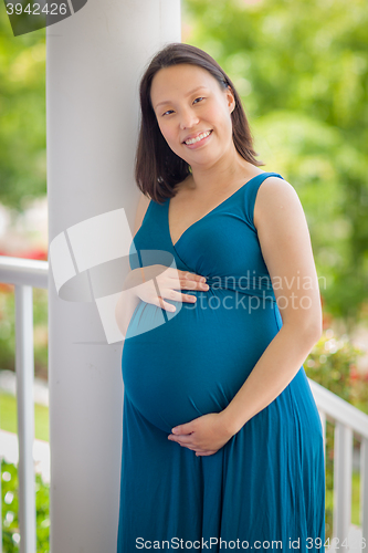 Image of Portrait of Young Pregnant Chinese Woman on the Front Porch