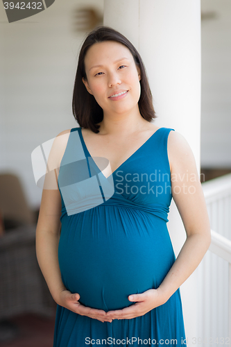 Image of Portrait of Young Pregnant Chinese Woman on the Front Porch