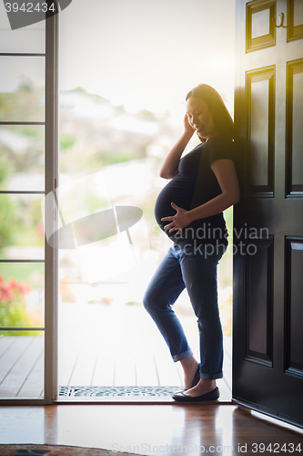 Image of Chinese Pregnant Woman Standing in Doorway