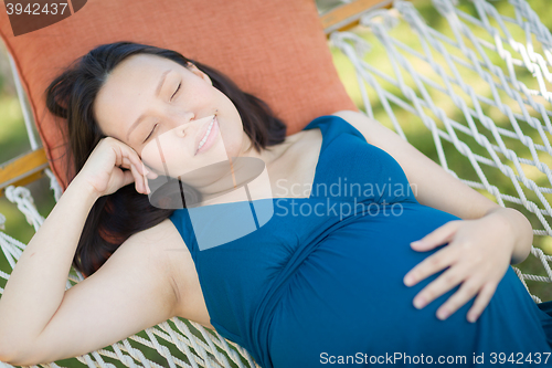 Image of Young Pregnant Chinese Woman Resting in Hammock