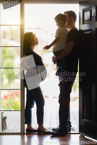 Image of Pregnant Woman with Husband and Son in Doorway