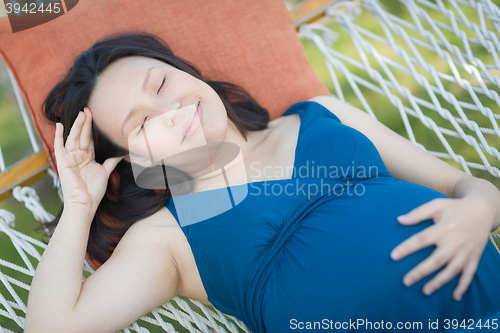 Image of Young Pregnant Chinese Woman Resting in Hammock