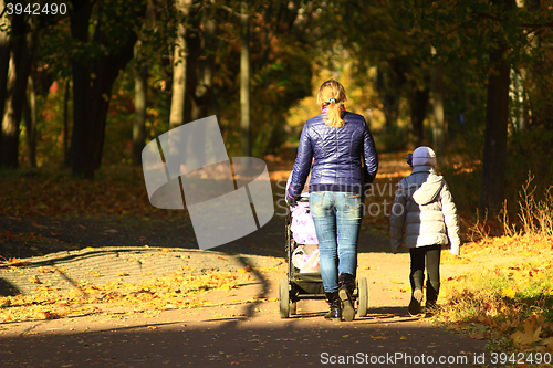 Image of woman with perambulator and elder child in park