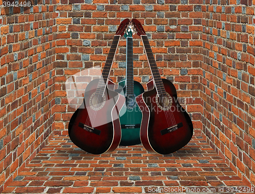 Image of three guitars in the corner of the brick room