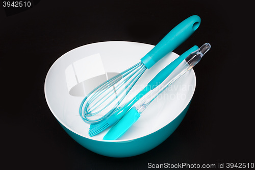 Image of Green silicone pastry brush and soup plate isolated on black