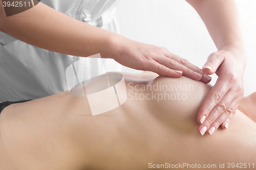 Image of Beauty young woman recieving breast massage at spa. masseur\'s hands on the woman\'s breast
