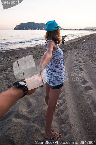 Image of Girl holding a hand man on the beach