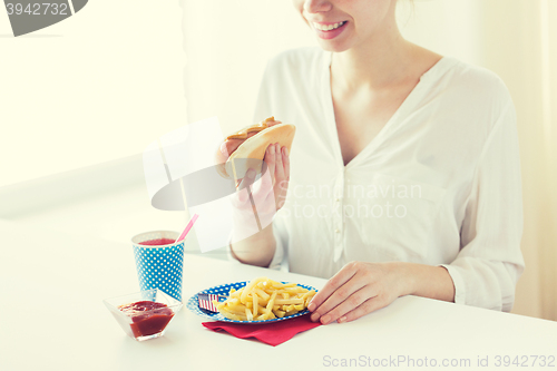 Image of close up of woman eating hotdog and french fries