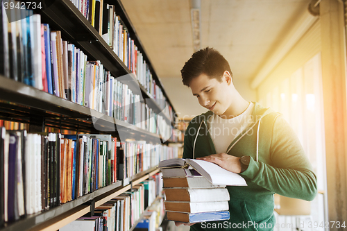 Image of happy student or man with book in library