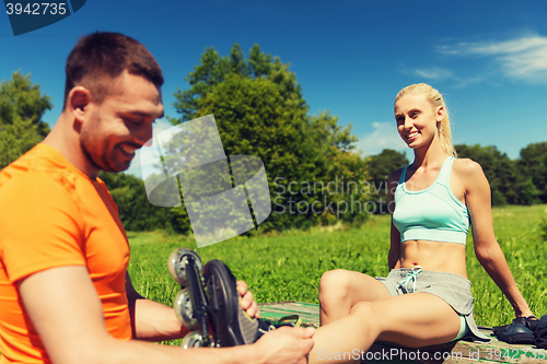 Image of happy couple with rollerblades outdoors