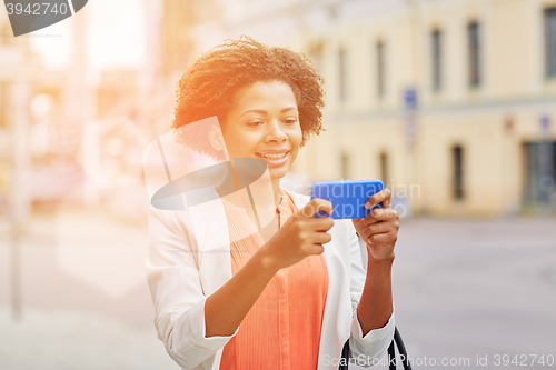 Image of happy african businesswoman with smartphone