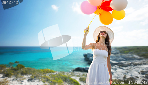 Image of smiling young woman in sunglasses with balloons