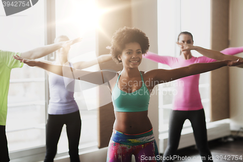 Image of group of smiling people dancing in gym or studio