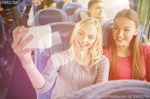 Image of women taking selfie by smartphone in travel bus