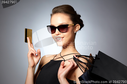 Image of happy woman with credit card and shopping bags