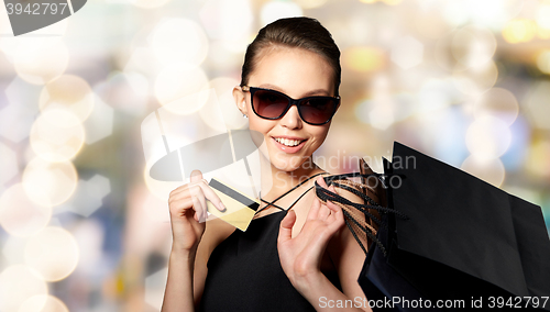 Image of happy woman with credit card and shopping bags