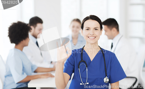 Image of happy doctor over group of medics at hospital