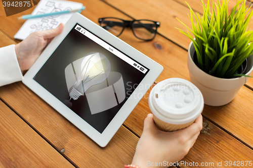 Image of close up of woman with light bulb on tablet pc