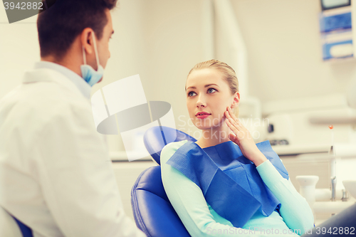 Image of male dentist with woman patient at clinic