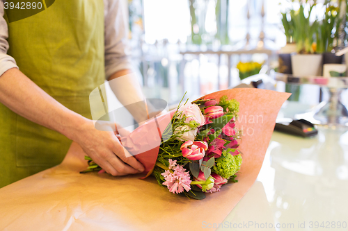 Image of florist wrapping flowers in paper at flower shop